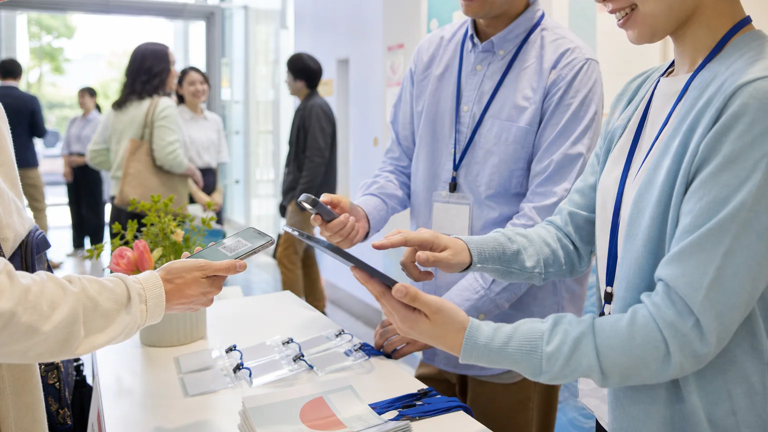 タブレットを使って来場者を受け付けるイベントスタッフ